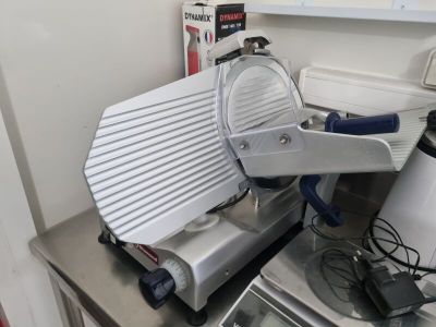 une trancheuse à viande posée sur un plan de travail de cuisine