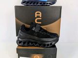 une paire de baskets noires et bleues posée sur une boîte
