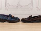 two pairs of shoes sitting on a wooden floor next to a wall