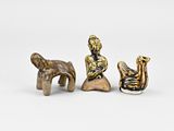 three figurines of a man and a woman sitting on a rock