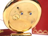 a gold clock with blue eyes on it next to a red box