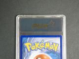 the pokemon card is in a clear plastic holder on a table