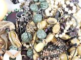 a pile of assorted beads and necklaces on a table