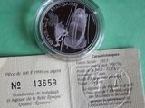 a silver coin with a picture of a man and a woman on it
