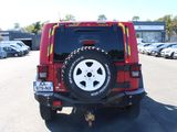 a red jeep parked in a parking lot with other cars
