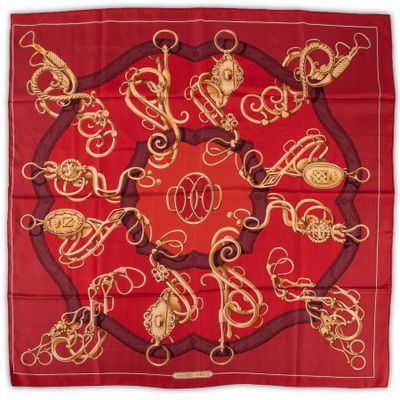 a red and gold scarf with a circular design on it