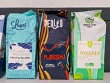 many different types of coffee bags lined up on a shelf