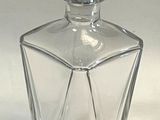 a clear glass bottle with a bird on top