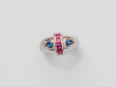 a close up of a ring with two blue and pink stones