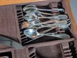 several spoons and spoon knives are in a case on a table