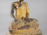 statue d'un Bouddha assis sur un rocher, sur fond gris