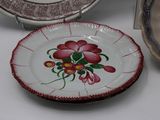 a plate with a flower painted on it next to other plates