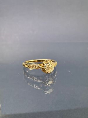 une photo d'une bague en or posée sur une table en verre
