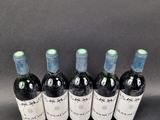 six bottles of wine are lined up in a row