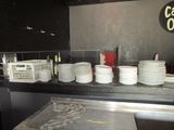 many plates and cups on the counter in the kitchen