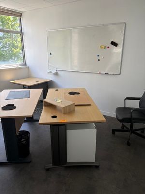 une photo d'un bureau vide avec un bureau et des chaises