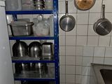 de nombreuses casseroles et poêles sur les étagères de la cuisine