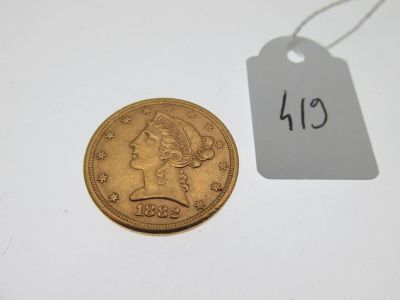 une pièce d'or sur laquelle est posée une étiquette indiquant son prix