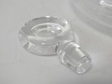 a clear glass bottle with a clear cap on a white table