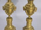 pair of antique brass urns on pedestals on a white background