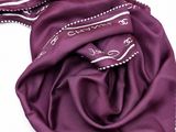the purple scarf is laying on top of a white surface