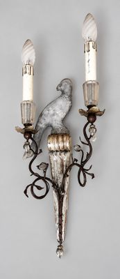 a bird sitting on a sconce on the wall