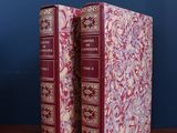 deux livres posés sur une table en bois près d'un mur bleu