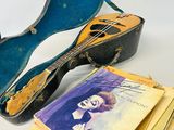 une guitare, un livre et un étui à guitare posés sur une table