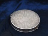a silver pill case sitting on top of a blue cloth