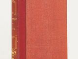 a red book sitting on top of a table next to a white wall