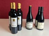 quatre bouteilles de vin sont alignées sur une table