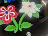 a black bowl with colorful flowers painted on it