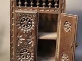 a small wooden cabinet with a door open on a table