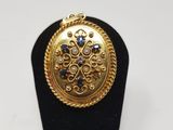 un gros plan d'une bague posée sur un socle noir, sur fond blanc
