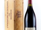 the bottle of red wine is next to a wooden box