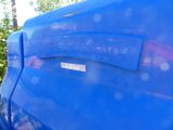 a close up of a blue truck parked in a parking lot