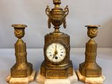 une horloge en or posée sur un socle en marbre