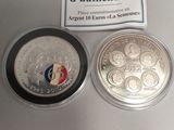 silver coin with a red, white, and blue design on it