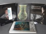 trois livres posés sur une table sur laquelle se trouve un vase