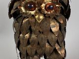 a sculpture of an owl made out of metal leaves