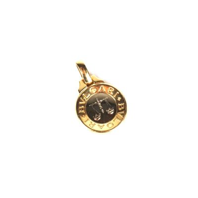 un gros plan sur une breloque en or sur laquelle figure une horloge