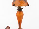 an orange glass lamp with a black base and a red lamp shade