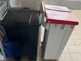 a picture of a kitchen with a trash can and a refrigerator