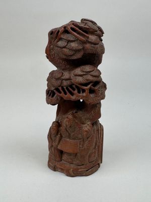 une vieille statue en bois représentant un oiseau avec un panier sur la tête