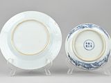 pair of blue and white plates with gold rims on stands