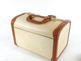 a white suitcase with a brown handle on a white surface