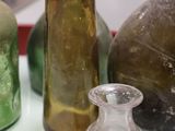 many different colored glass bottles sitting on a table