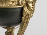 a black and gold vase with a face on it