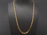 a gold chain necklace on a mannequin display