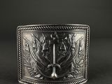 a close up of a silver belt buckle on a black background